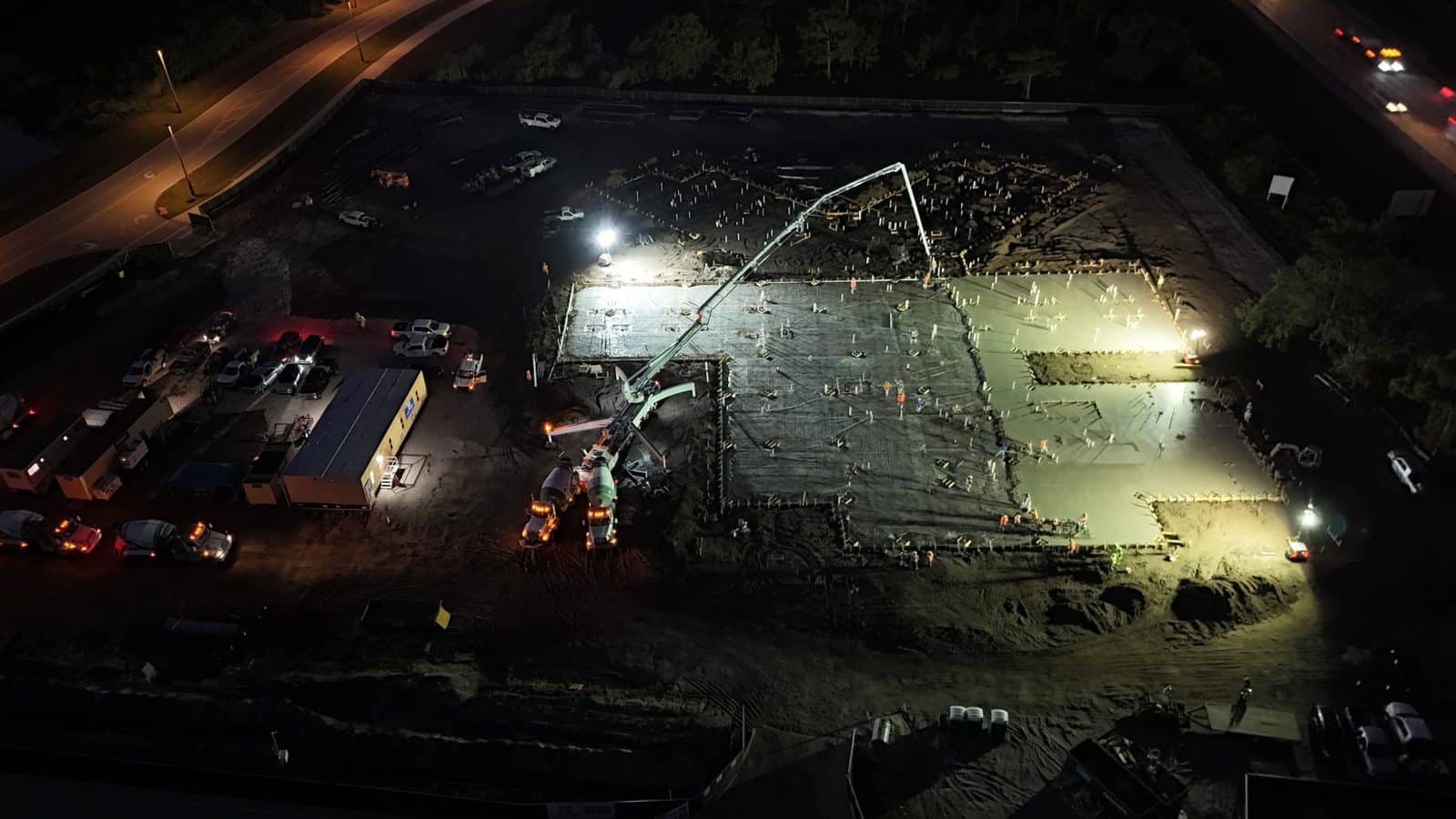 Aerial night view of a large commercial concrete slab pour under work lights